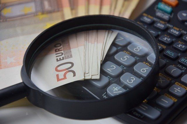 Geld und Taschenrechner unter der Lupe