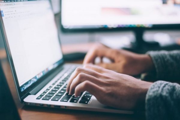 Mann arbeitet an einem Laptop am Digitalen Schadenmanagement