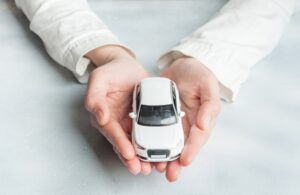Spielzeugauto wird vorsichtig in den Händen gehalten