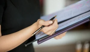 Person mit Fahrzeugcheckliste in der Hand