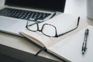 Brille liegt auf Notizheft