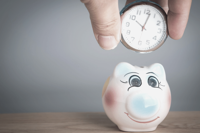 Eine Uhr über einem Sparschwein