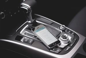 Smartphone mit Fahrtenbuch App liegt im Auto.