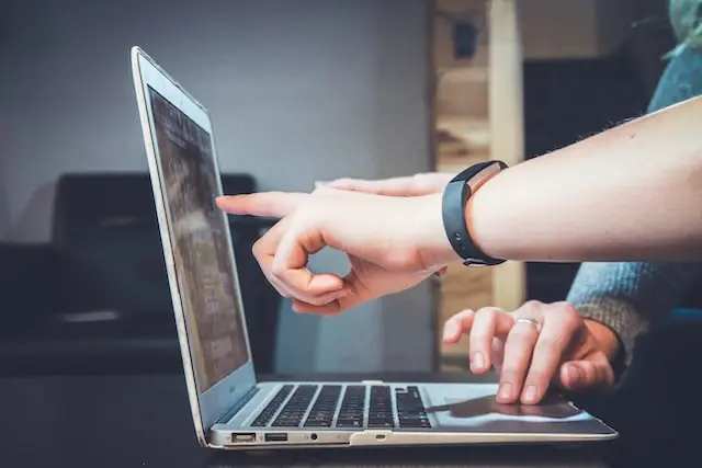 Finger zeigt auf Laptop Bildschirm