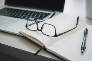 Brille liegt auf Notizbuch