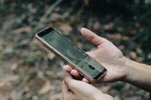 Ein Handy mit einer Tracking Software wird gehalten