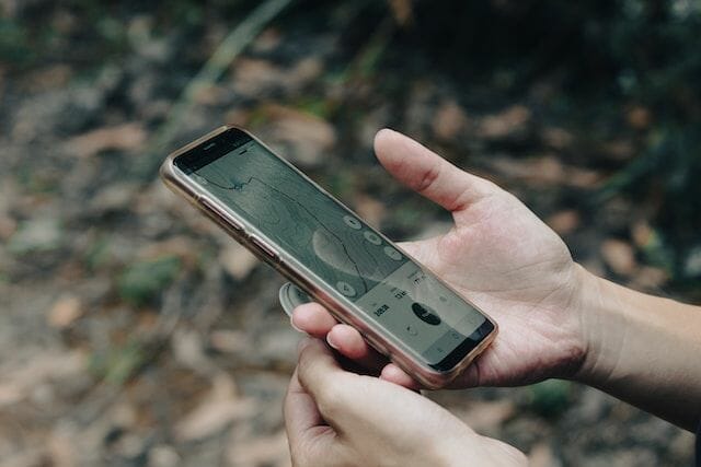 Ein Handy mit einer Tracking Software wird gehalten
